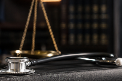 Stethoskop und Justizsymbole als Symbol für Strafverteidigung im Medizinstrafrecht